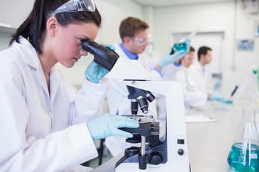 Scientists at work in a laboratory with microscopes and other equipment